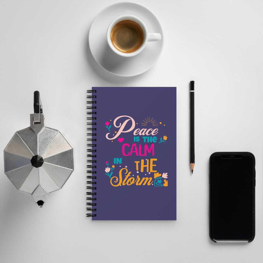Peace Is the Calm in the Storm Christian spiral notebook on a desk with coffee